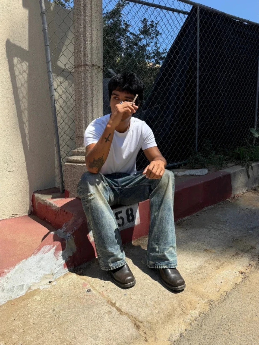 WORN — FLARED JEANS — model wearing blue washed jeans while seated