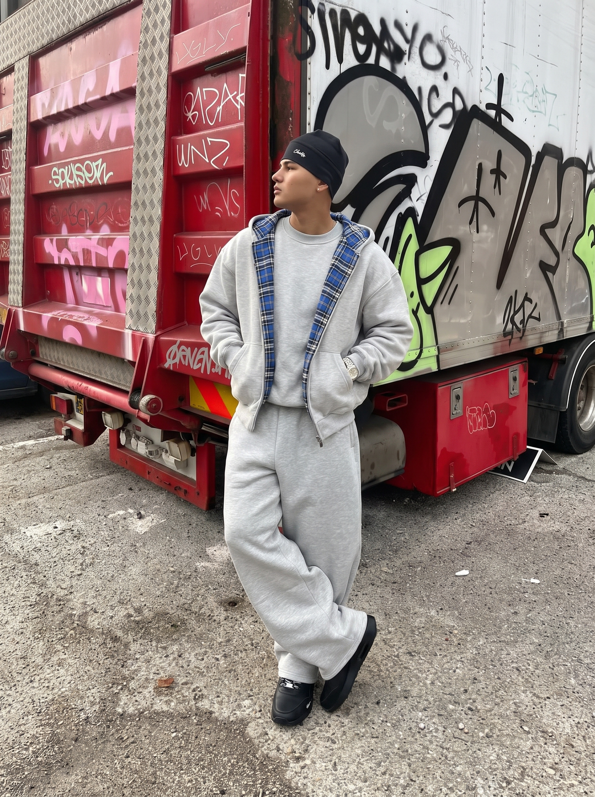 REVERSO — CHECK HOODIE JACKET — grey jacket with blue check lining on model by painted truck